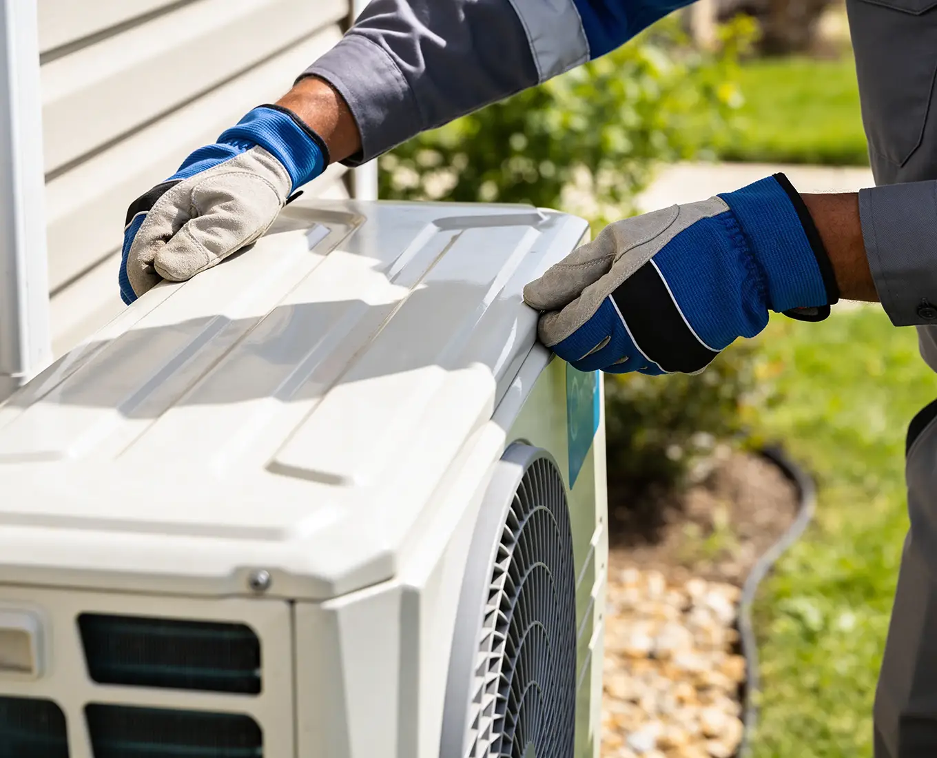 HVAC technician performing maintenance on an outdoor AC unit in Collinsville, IL to ensure peak performance.