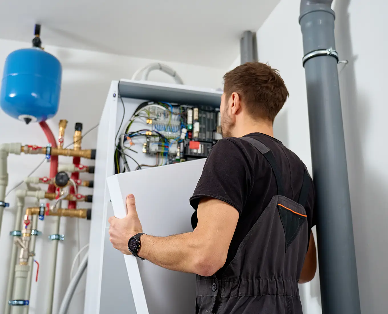 hvac technician checking the inside of an HVAC unit.