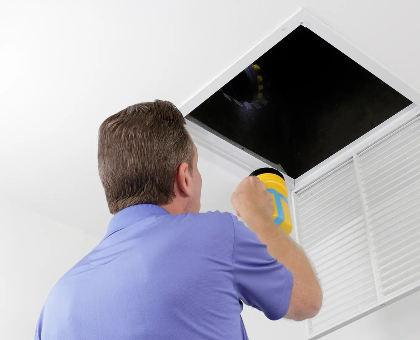 technician inspecting an air duct