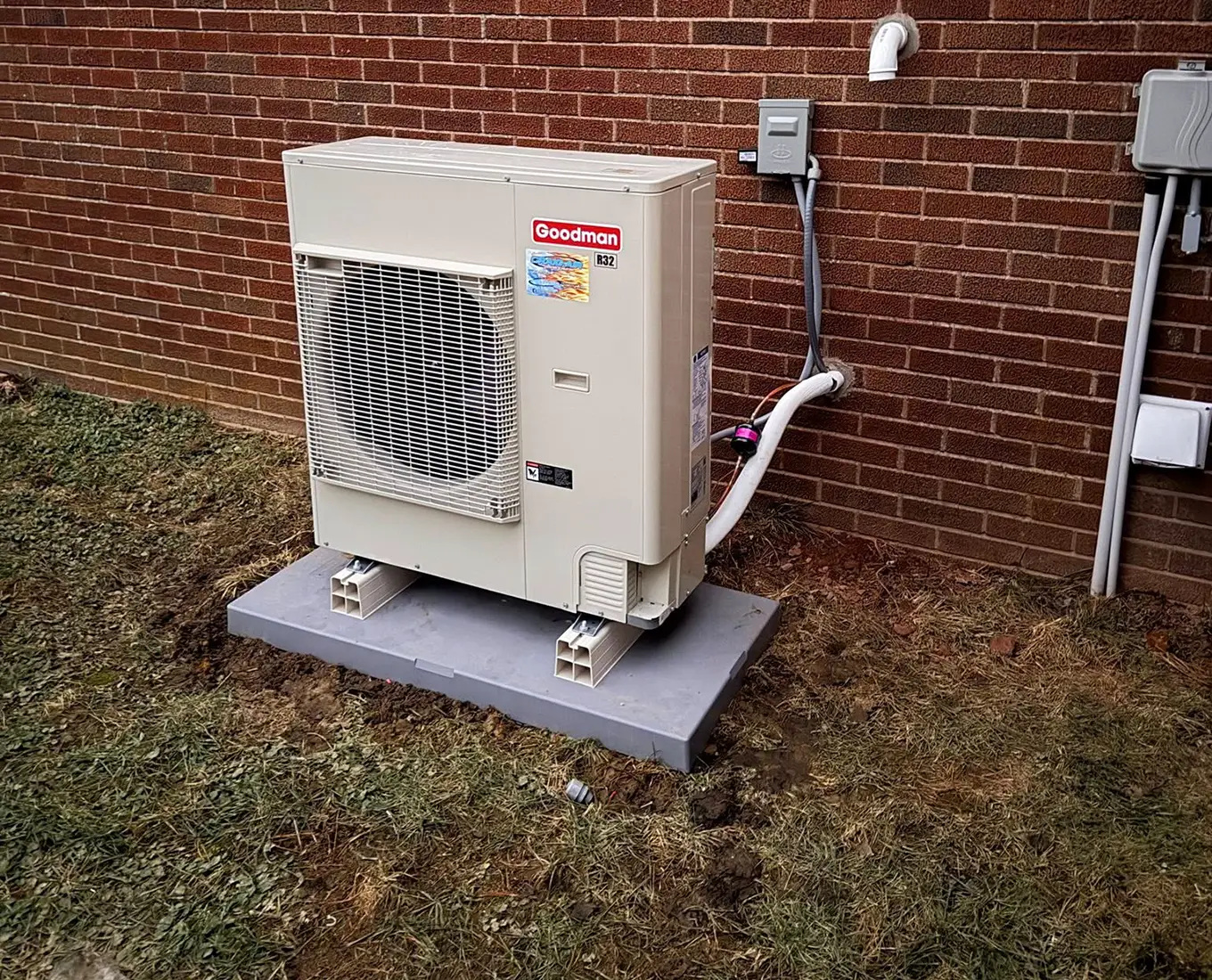 Ductless mini-split heat pump system mounted outside a Troy, IL brick home for energy-efficient heating and cooling.