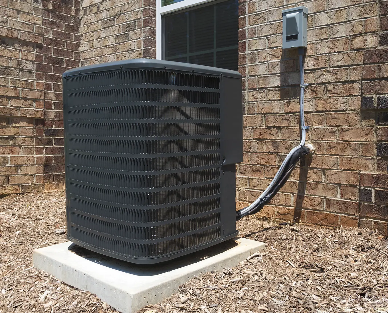 Outdoor central air conditioning unit installed beside a Highland, IL home for efficient summer cooling.