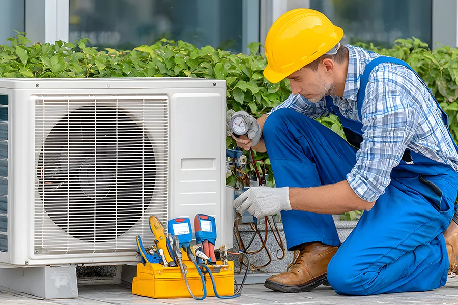 HVAC technician installing or servicing an outdoor heat pump or air conditioning unit, ensuring energy efficiency and comfortable climate control for modern homes in o'fallon il