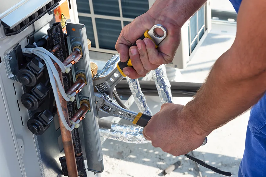 HVAC technician is working on air conditioner units on a roof of new industrial building in o'fallon il